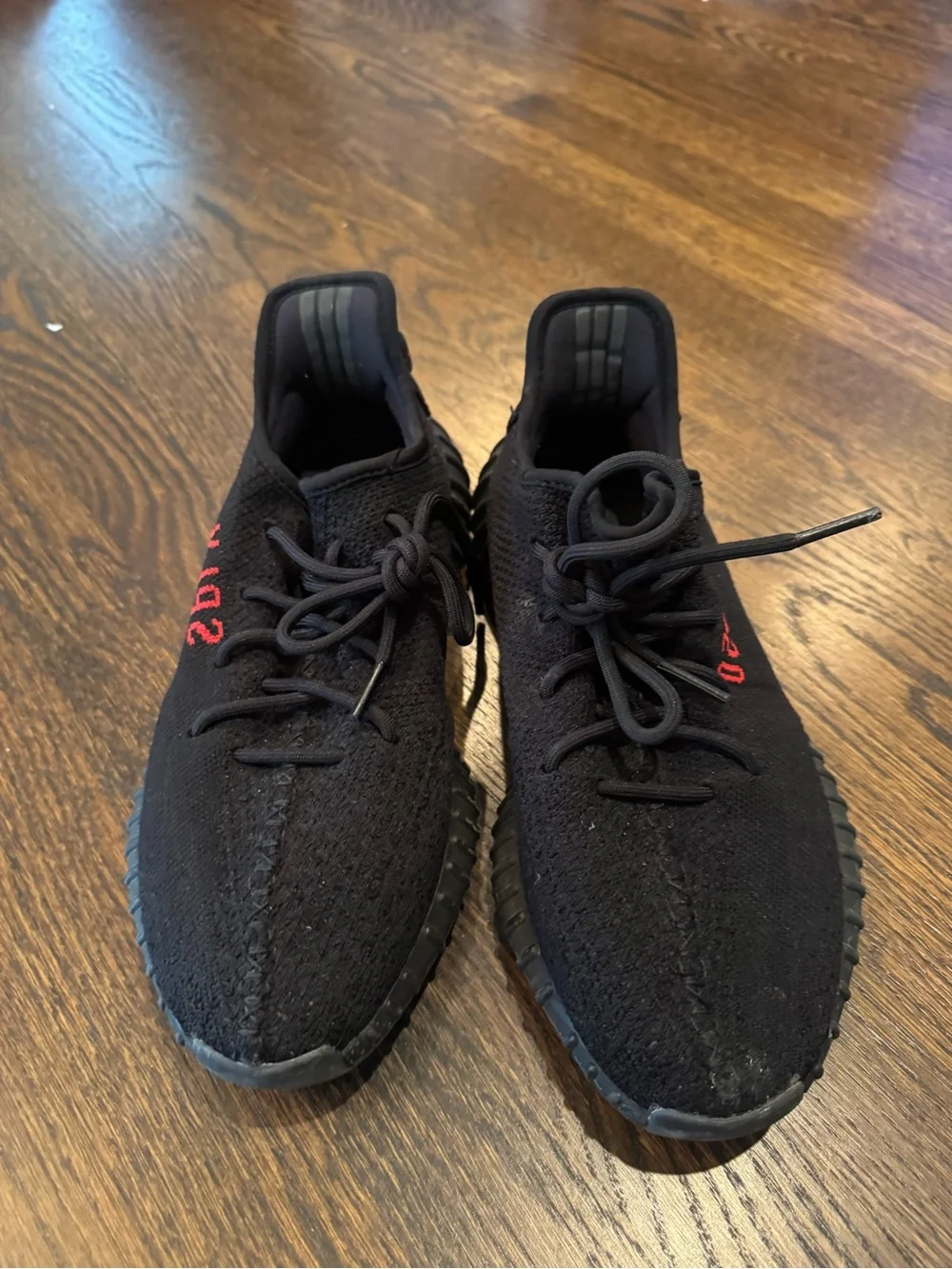 Black Yeezy 350 sneakers with red text